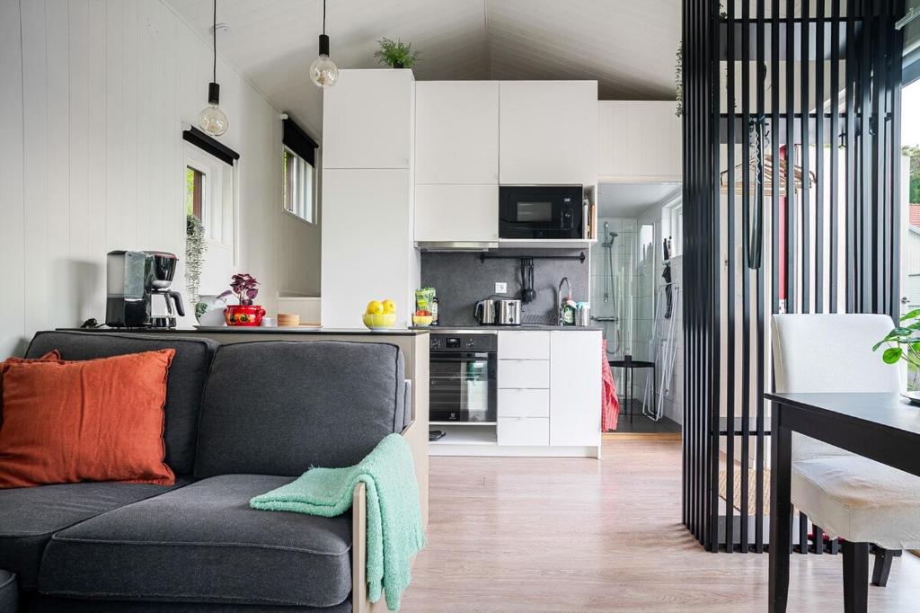 Una sala de estar con un sofá y una cocina. en Cute and Cozy Guesthouse near Water, en Tyresö