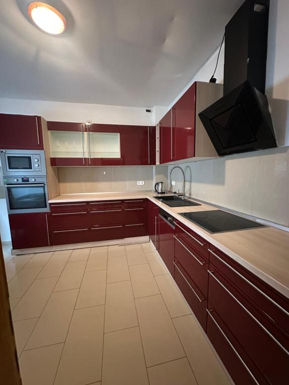 a kitchen with red cabinets and a sink and a stove at Shakina Residences near Frankfurt Airport in Rüsselsheim