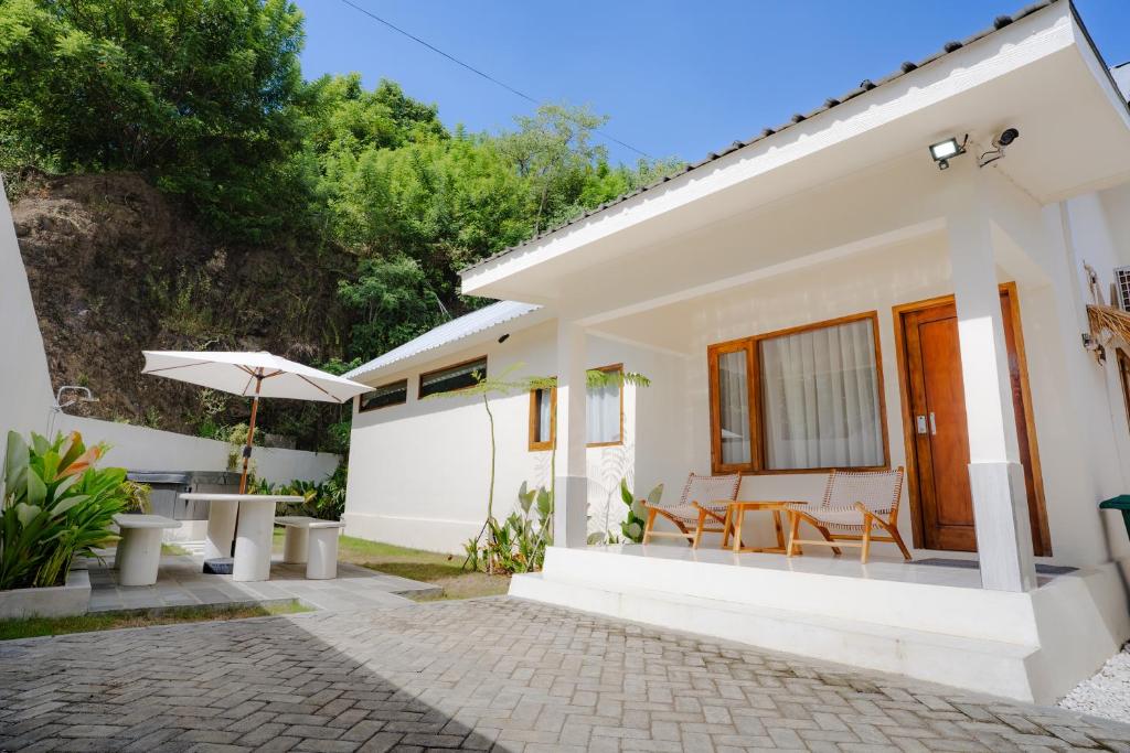 una casa bianca con patio e ombrellone di Central house with 2 large bedrooms a Kuta Lombok