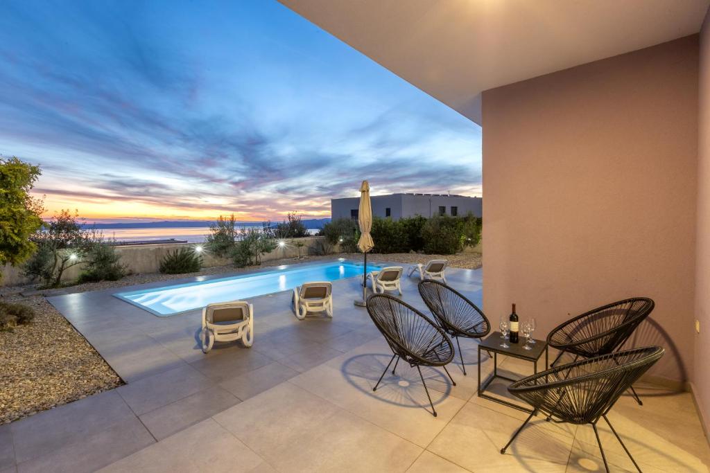 a patio with chairs and a swimming pool at VILLA VIS MARIS in Makarska