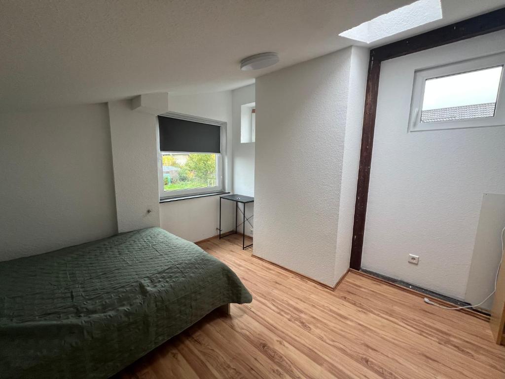 a bedroom with a green bed and a window at WG-Zimmer-Erstbezug nach Sanierung -Vollmöbliert in Taunusstein