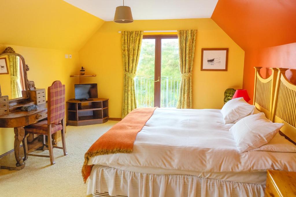 a bedroom with a bed and a desk and a window at Ocean View Lodge in Kilchiaran
