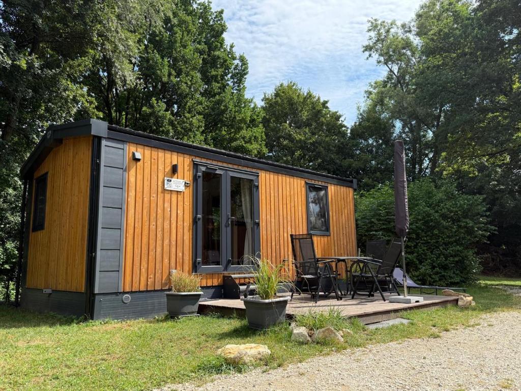 a small shed with a table and chairs in a yard at Waldseechalet Julius - Wemding in Wemding