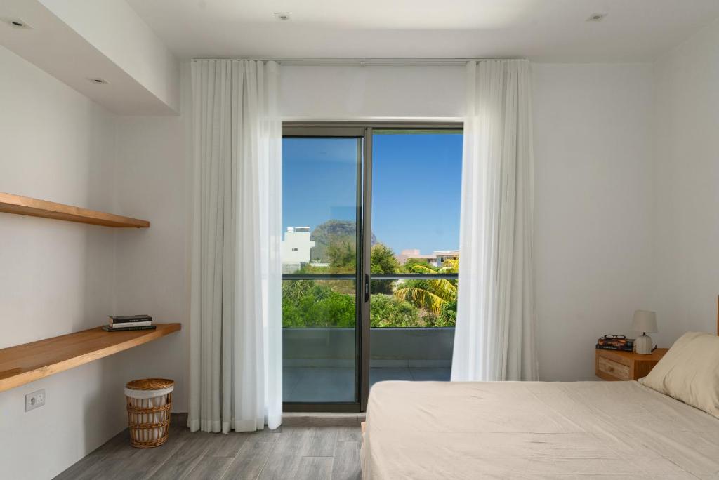 a bedroom with a large window with white curtains at Serenity in La Gaulette