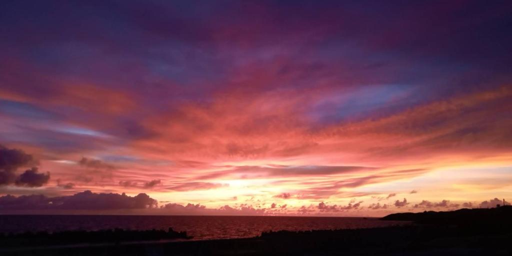 a sunset over the ocean with a colorful sky at Locanda katsuren 勝連荘 in Miyako Island