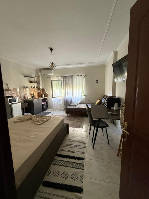 Un dormitorio con una cama y una cocina con una mesa. en Koa Studio 1, en Korçë