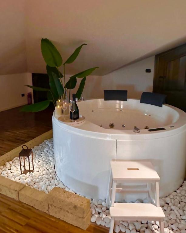 a white bath tub with a potted plant in a room at Suite Cascina Balocco in Neive