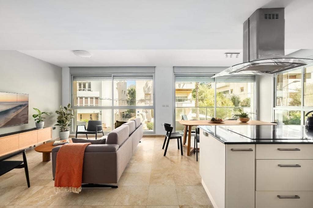 a kitchen and living room with a couch and a table at Gordon Beach Bright Spacious Stay in Tel Aviv