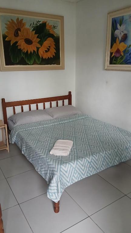 a bed with a blue comforter in a room at Pousada Costeira Barra do Sul in Balneario Barra do Sul