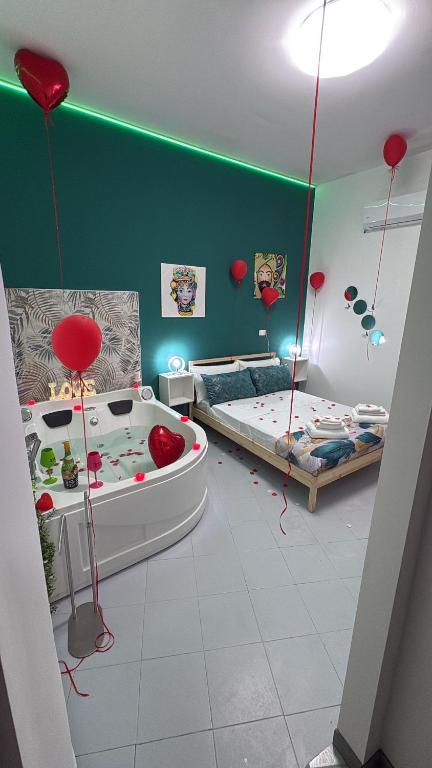 a room with two beds and a tub with hearts on the walls at House Mari in Catania