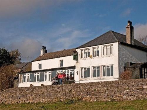 a large white house behind a stone wall at Lathkil Hotel in Bakewell
