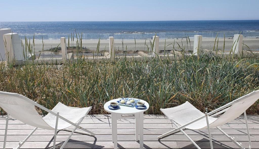 two chairs and a table with a tableasteryasteryasteryasteryasteryasteryasteryastery at Joli studio Hardelot face mer, à 100m du centre-ville! in Hardelot-Plage