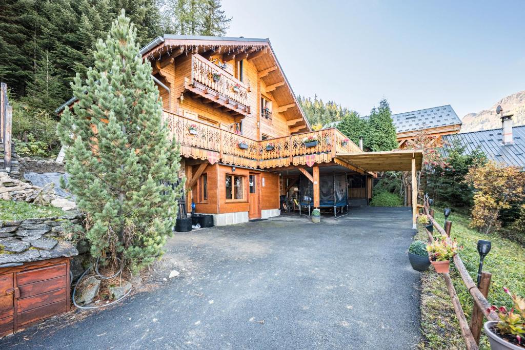 a large wooden house with a driveway in front of it at Bas De Chalet Lout'Chi Valfréjus in Valfréjus