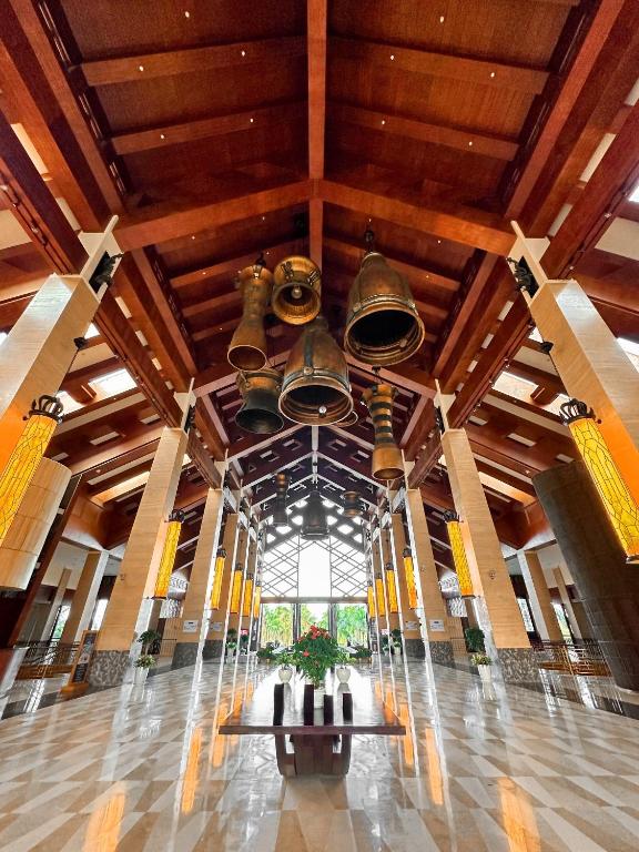 A grand timber-roofed lobby centered on a dramatic display of hanging bells.
