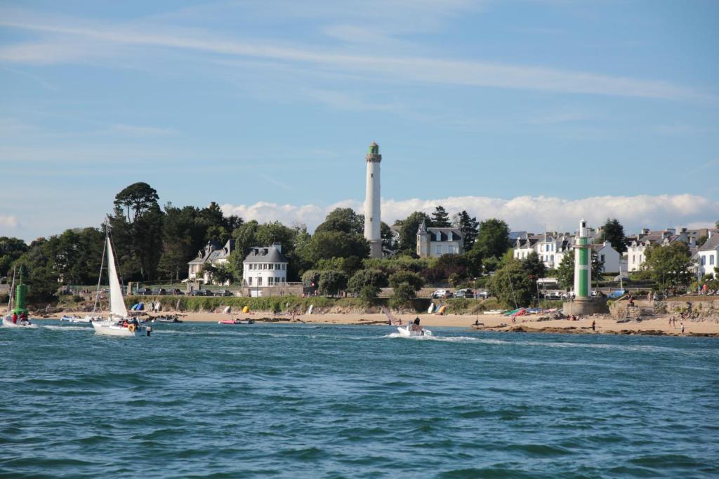 a group of people on boats in the water near a beach at Le Cornouaille Hotel & Spa in Bénodet