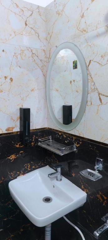 a bathroom with a white sink and a mirror at Hotel Prince palace in Ayodhya