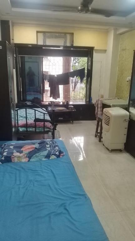 a bedroom with a bed and a desk and a window at Lakeside in Mumbai