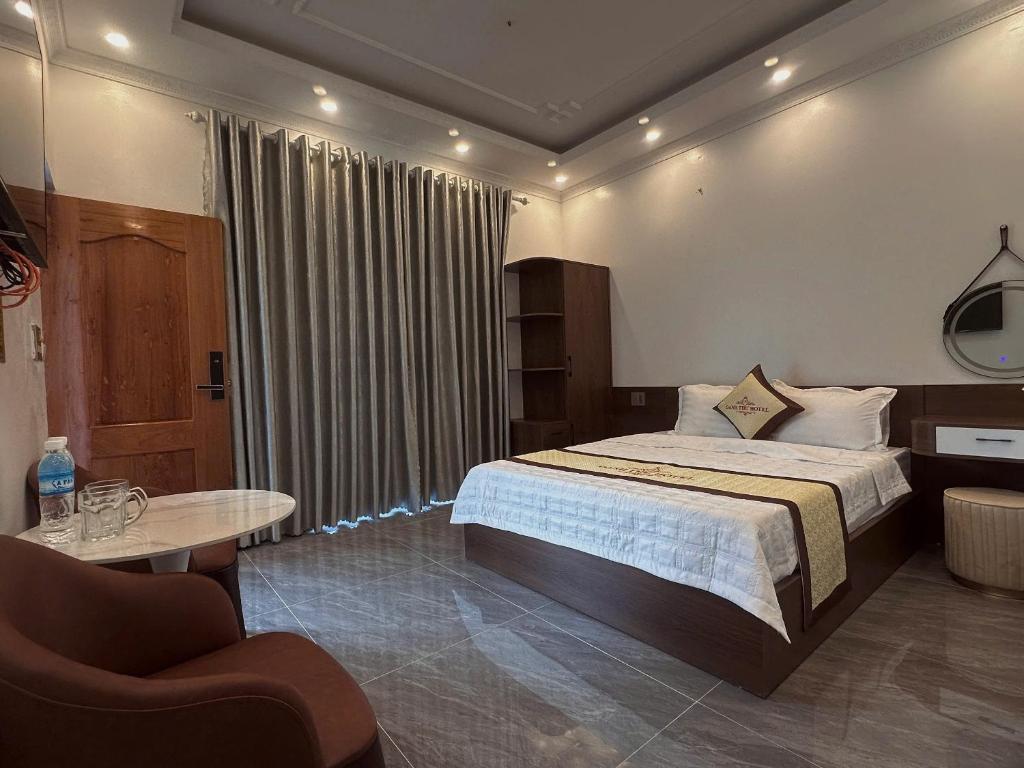 a bedroom with a bed and a table and a chair at Oanh Thư Hotel in Mèo Vạc