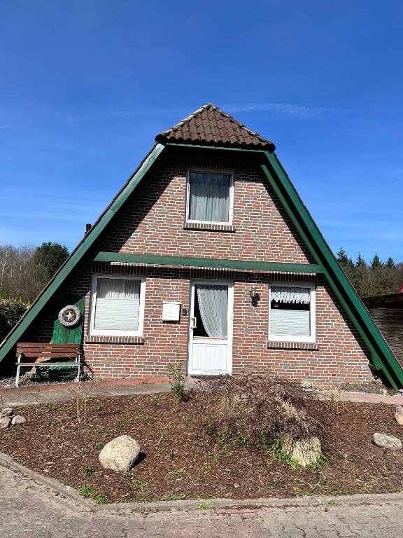 a brick house with a bench in front of it at Rehblick RE11 in Sögel