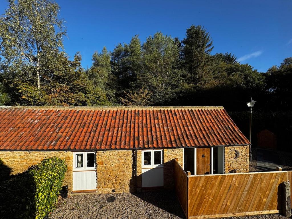 an old brick building with a red roof at Forest Edge, Wykeham Forest in Scarborough