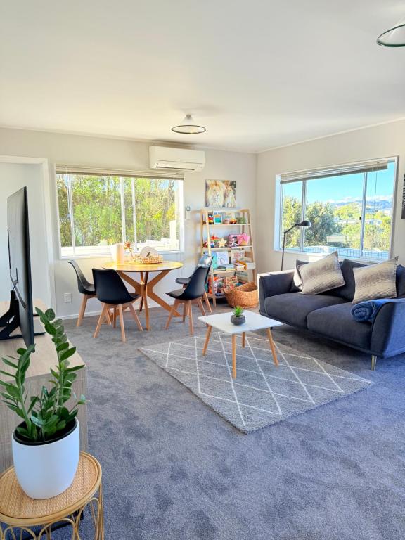 a living room with a couch and a table at Renovated Entire 2BR Flat, Comfort, Scenic Views, Free Parking & 10 min to Ferry in Wellington