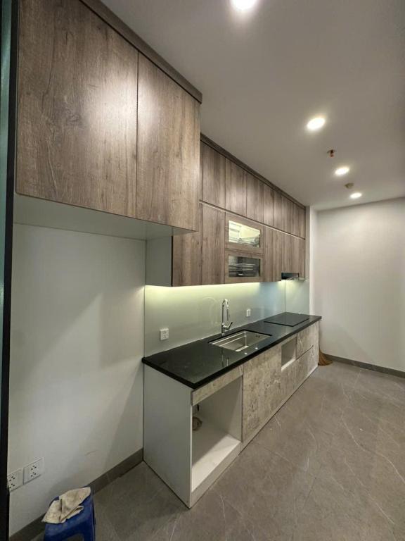 a large kitchen with a sink and wooden cabinets at H-Vista Suites - The Wisteria 