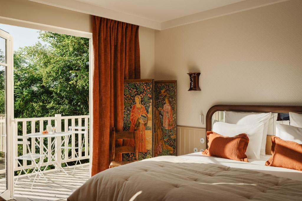 a bedroom with a bed and a balcony at Maison Roz Superbe maison face à l'Aven in Riec-sur-Bélon
