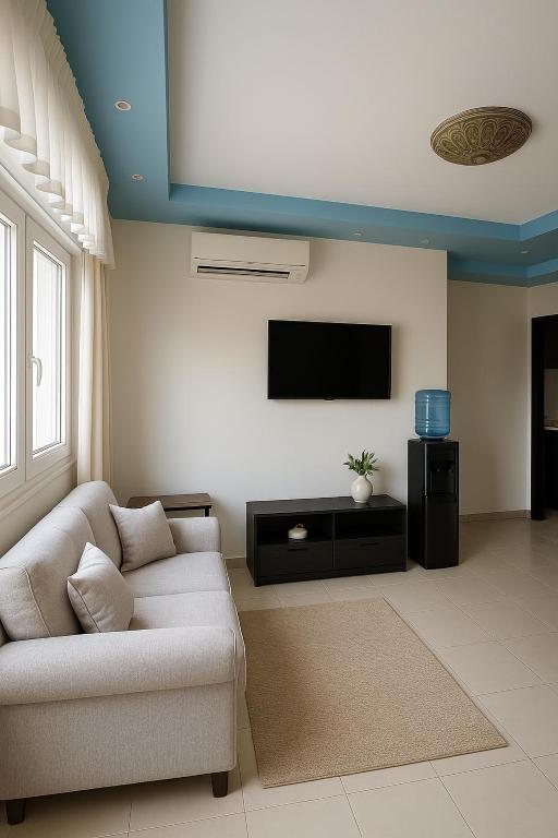 a living room with a couch and a flat screen tv at Sea Breeze Apartment Sharm el-Sheikh in Sharm El Sheikh