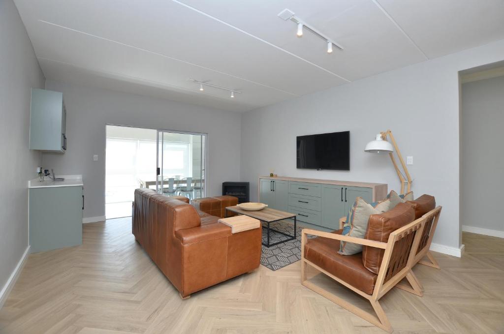 a living room with a couch and a table at Villa 65 in Yzerfontein
