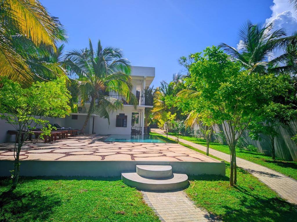 a house with a garden with a stone patio at Blue skies guest house and restaurant in Tangalle