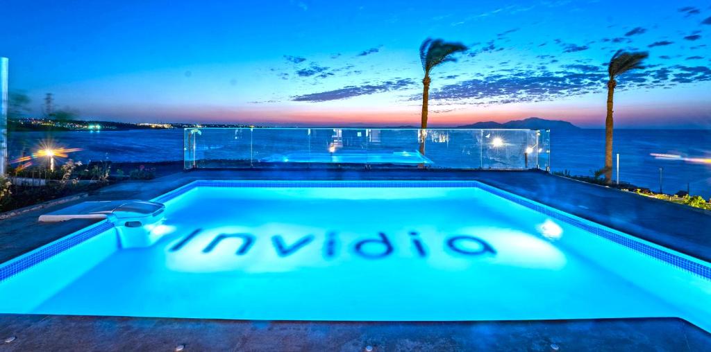 Invidia Coral Beach Tiran في شرم الشيخ: مسبح مطل على المحيط ليلا