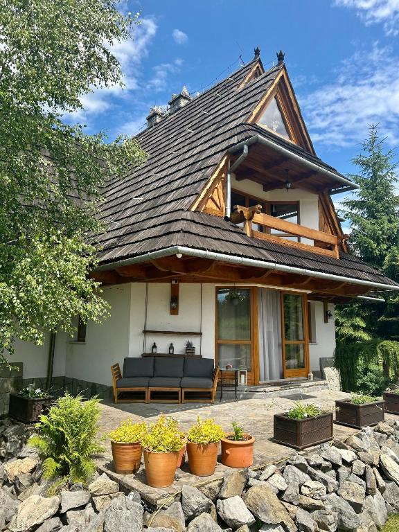 a house with a roof with potted plants at Willa Hamry z Jacuzzi i Sauna in Poronin