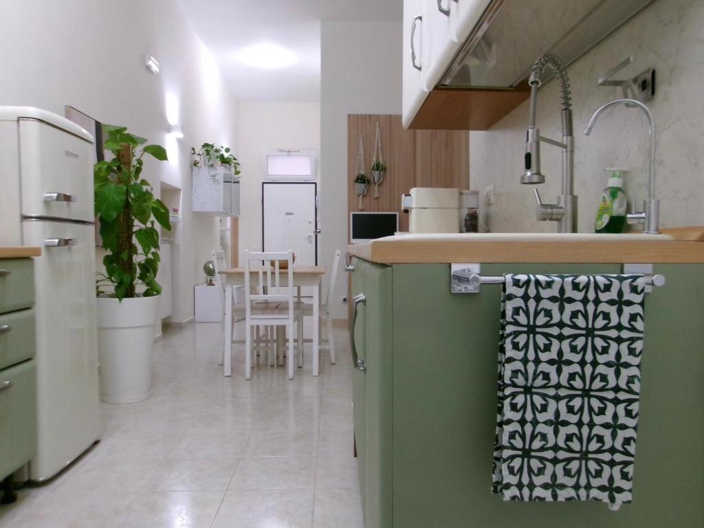 Il comprend une cuisine équipée d'un réfrigérateur vert et d'une table. dans l'établissement Val Lì, à Palagiano