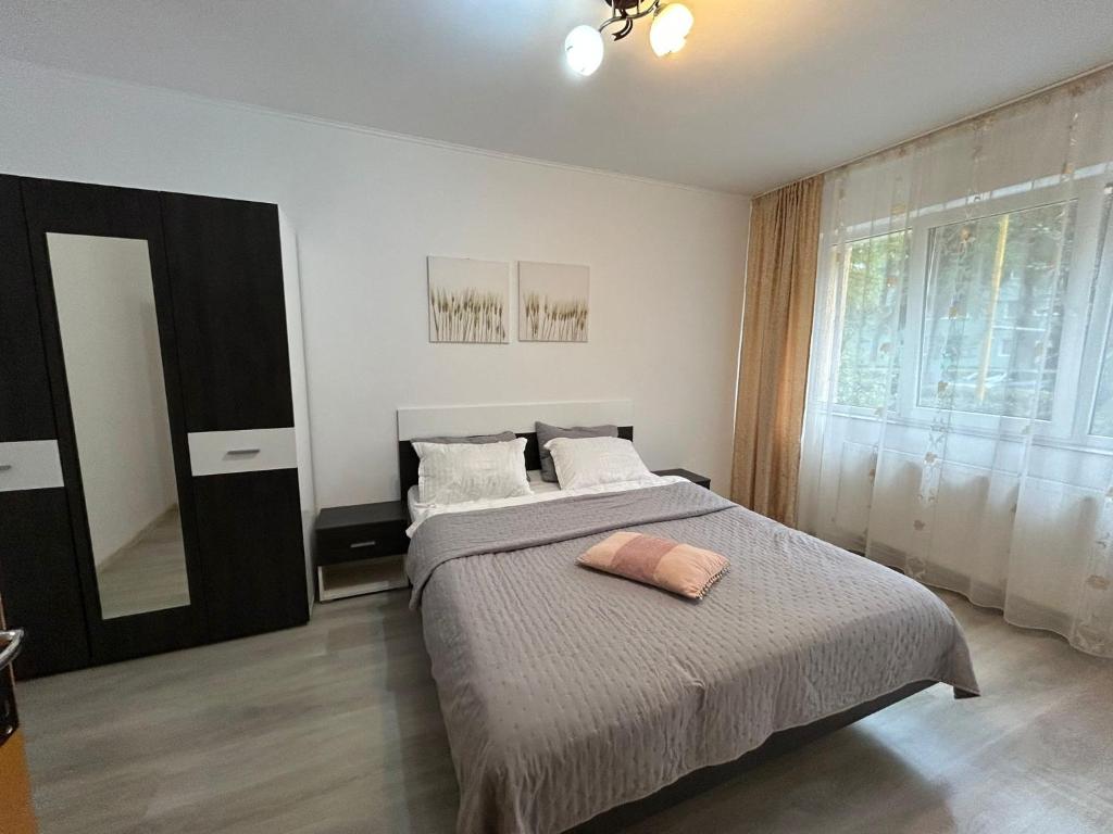 a bedroom with a bed and a large window at Aparthotel Brasov Neptun in Braşov