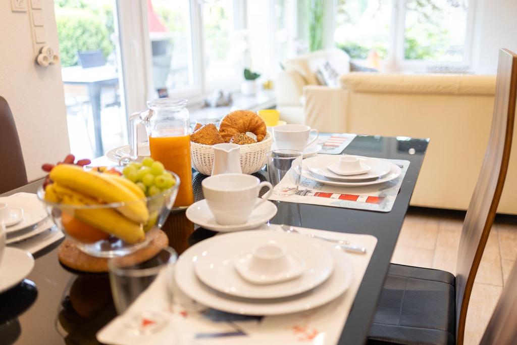 a table with a plate of food and a bowl of fruit at Ferienhaus Robbenglück - Ihr Rückzugsort an der Nordsee für Familien, Gruppen und Erholungssuchende in Butjadingen OT Tossens