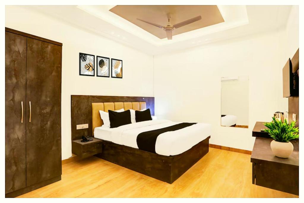 a bedroom with a large bed with black and white sheets at Hotel Ganraj Residency Near Laxmi Temple in Shirdi