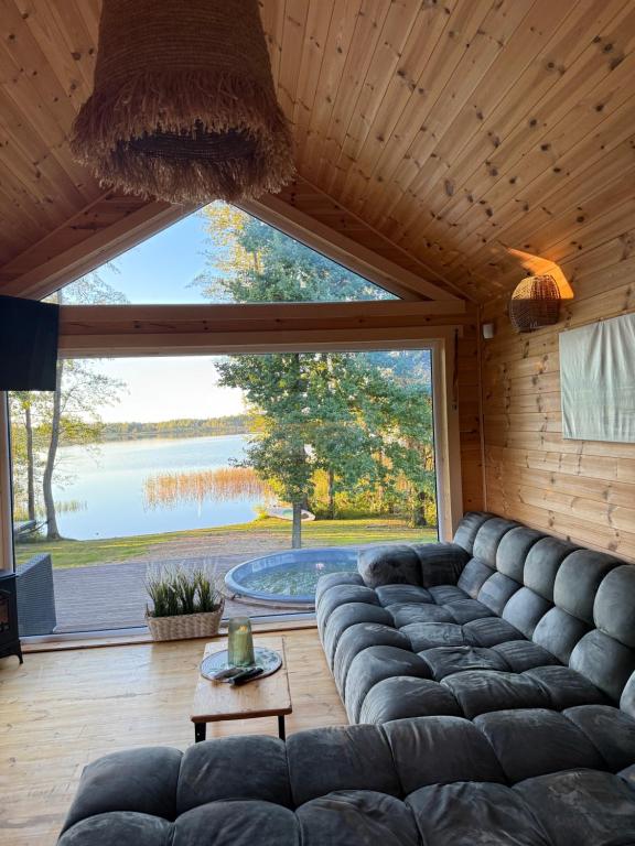 a living room with a couch and a large window at Jack namai in Puodžiai