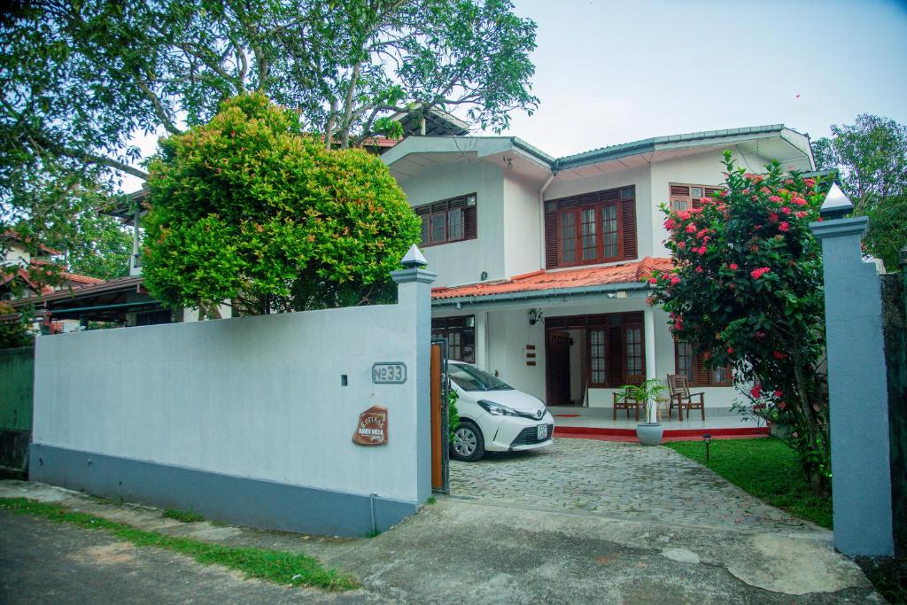 ein weißes Haus mit einem davor geparkten Auto in der Unterkunft Cottage Haven Villa in Galle