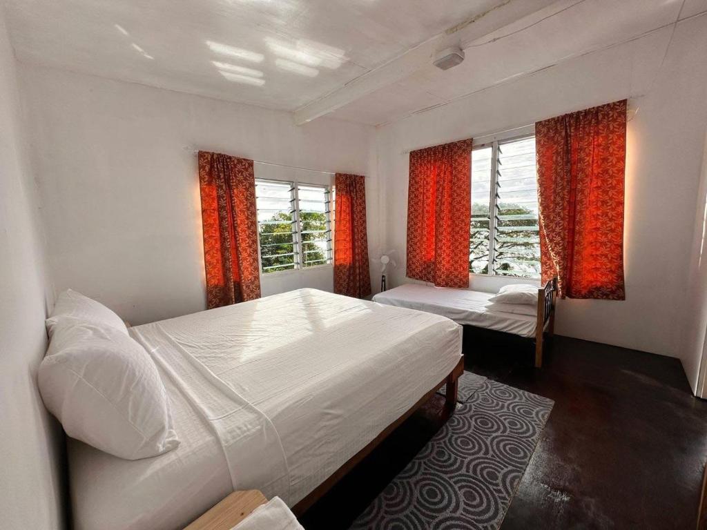 a bedroom with two beds and two windows at Tandra Island View Lodge 
