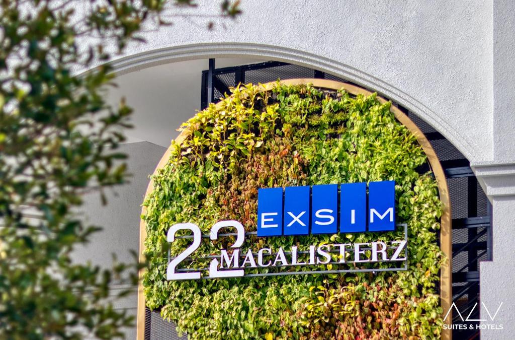 un panneau sur le côté d'un bâtiment dans l'établissement 22 Macalisterz by ALV, à George Town