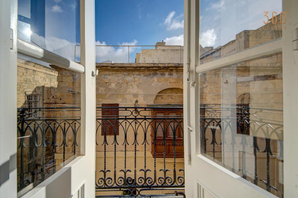 an open window with a view of a building at Suite Victory Beautiful fully equipped 2BR Townhouse by 360 Estates in Birgu