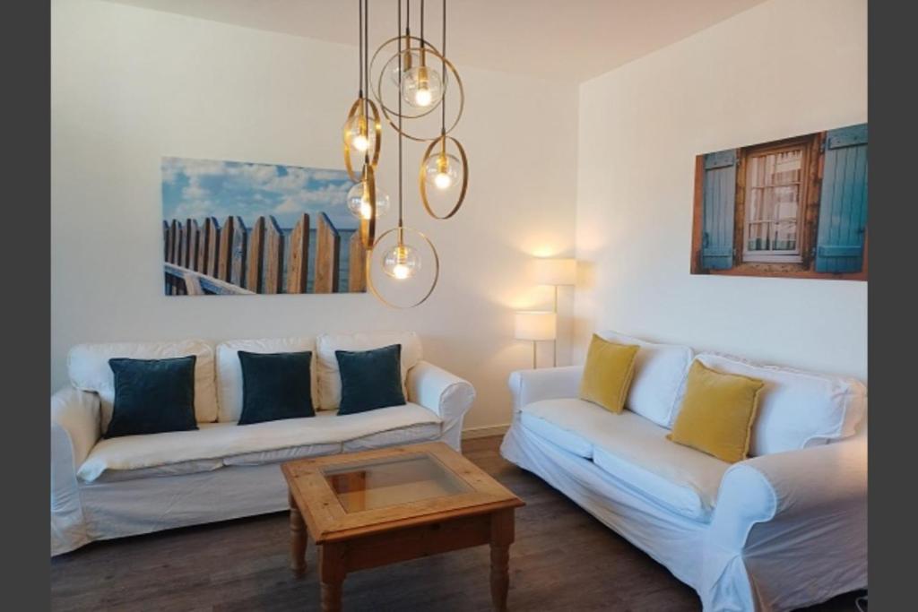 a living room with two white couches and a coffee table at Ferienwohnung Landhaus 44 Citynah, toskanischer Flair in Hamburg
