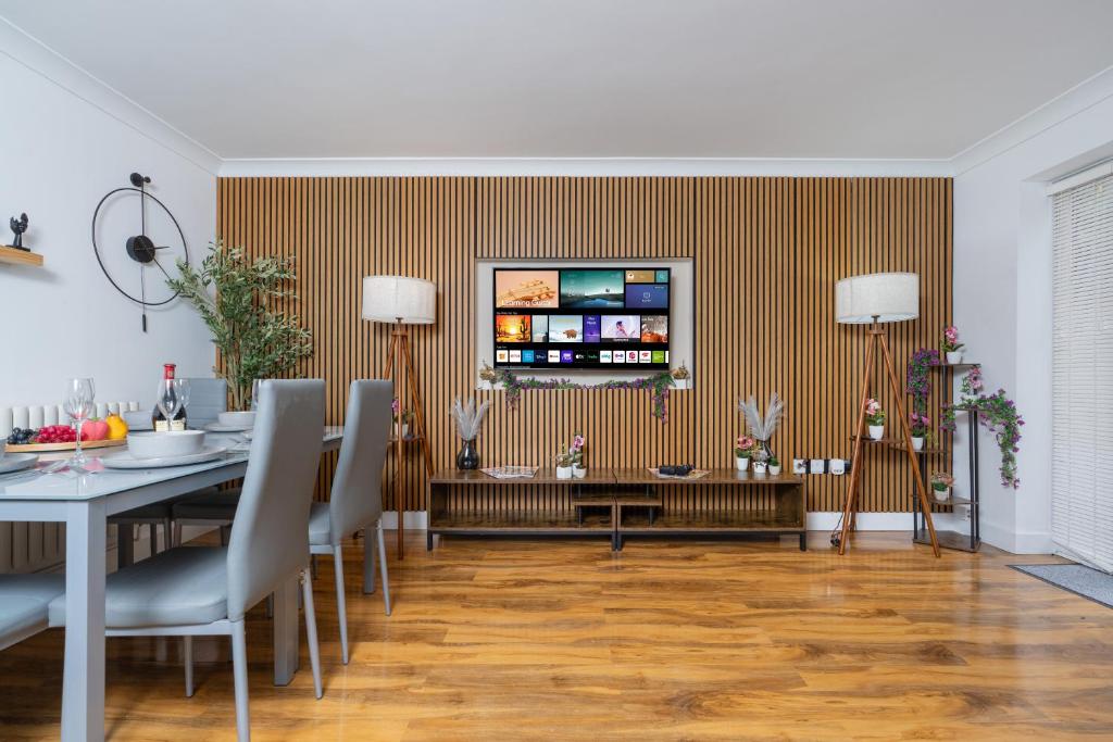 a dining room with a table and a television on a wall at Open Mind Property - 3 Bed Home with Free Parking in Portsmouth