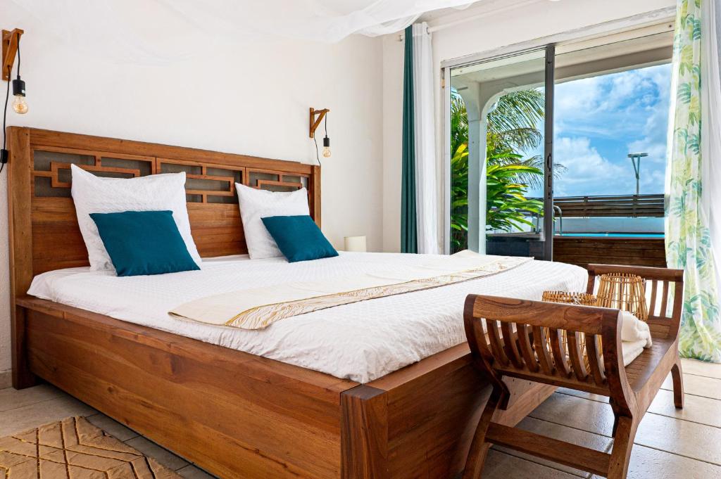 哥西尔Villa Au Coeur des Iles - Marina Gosier的一间卧室，配有一张大床和一扇窗户。