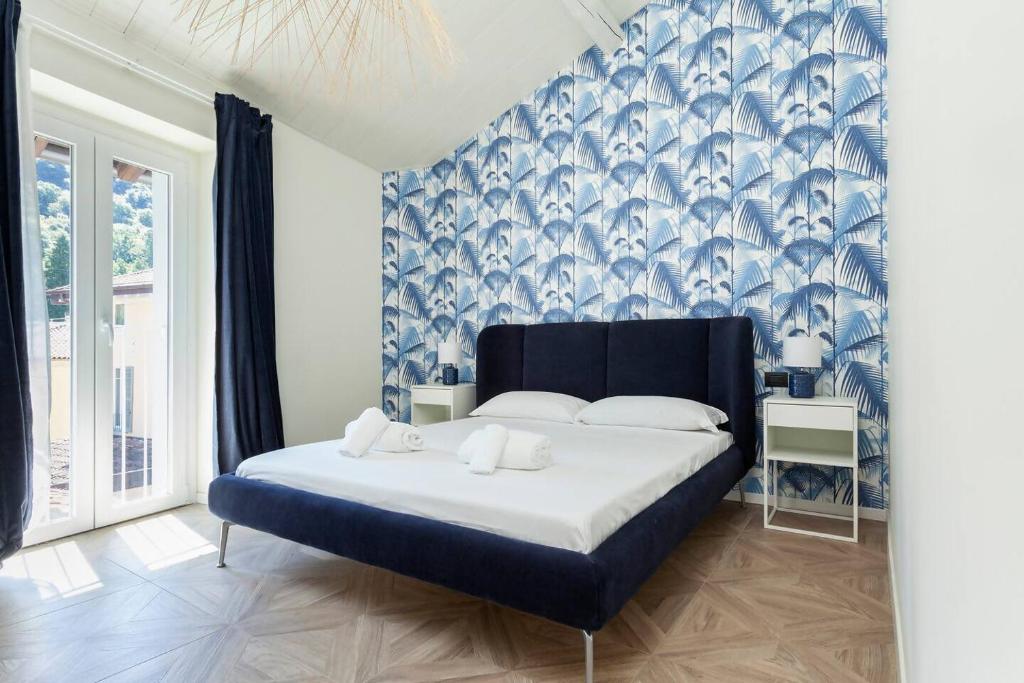 レンノにある"The Balbianello Lake House Blue"のベッドルーム1室(青と白の壁紙のベッド1台付)