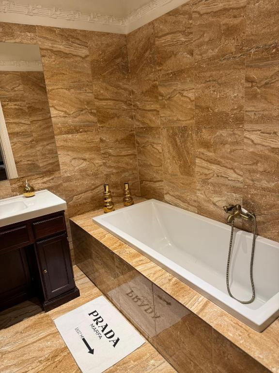 a bathroom with a tub and a sink at ROYAL Apartment in Kadaň