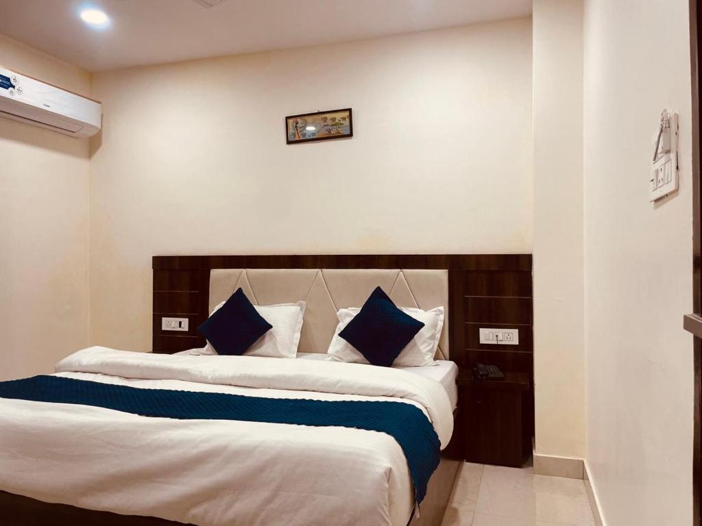 a bedroom with two beds with blue and white pillows at The Conifer View - Budget Friendly !! Lift !! Parking !! Spacious Room !! Family Friendly in Haridwār