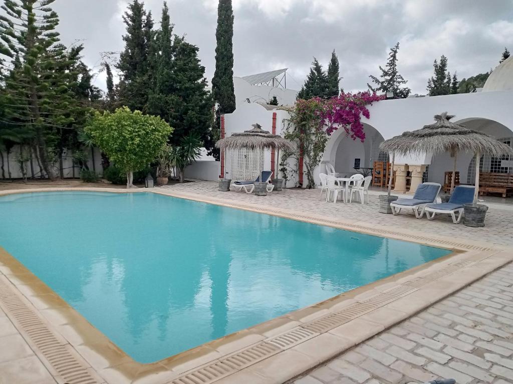 una piscina frente a una villa en Dar El kharrouba, en Hammamet Nord