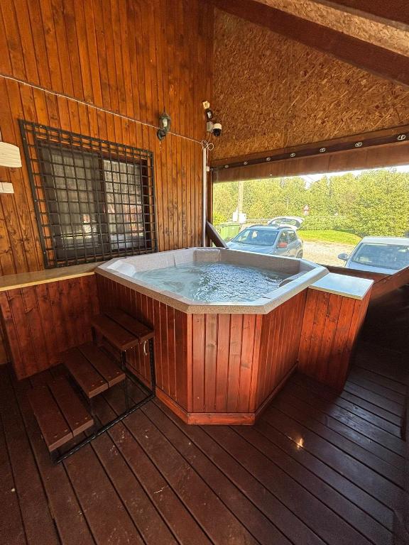 a hot tub on a wooden deck with a car parked at Copacabana Sinteu in Şinteu