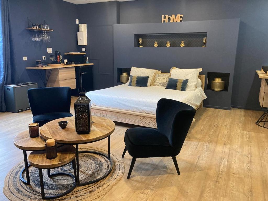 - une chambre avec un lit, deux tables et une chaise dans l'établissement Appartement avec spa privatif, à Douai